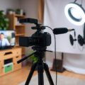 Person recording YouTube video with professional camera setup showing how to make money through YouTube