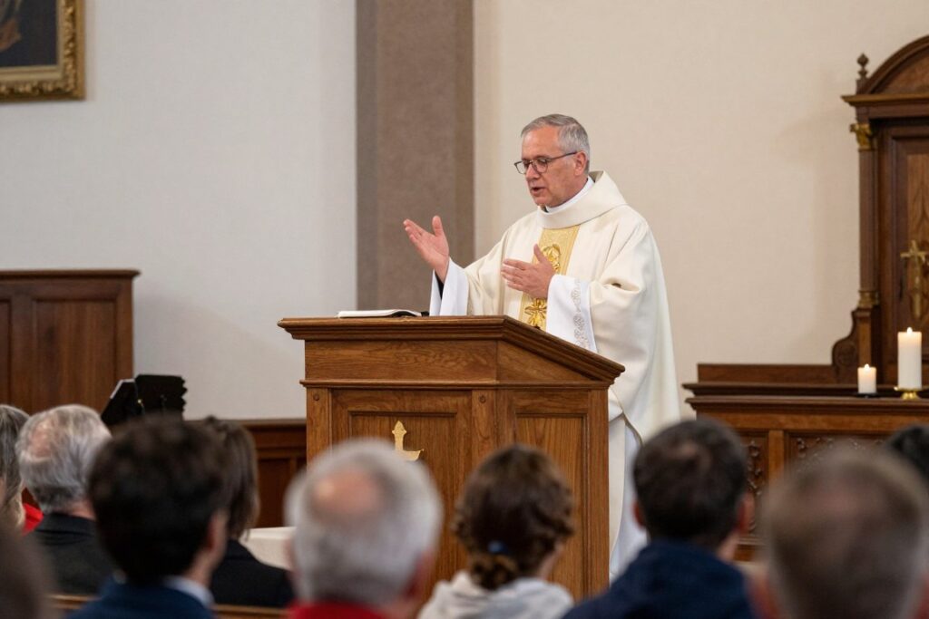 Priest delivering homily from pulpit to attentive congregation